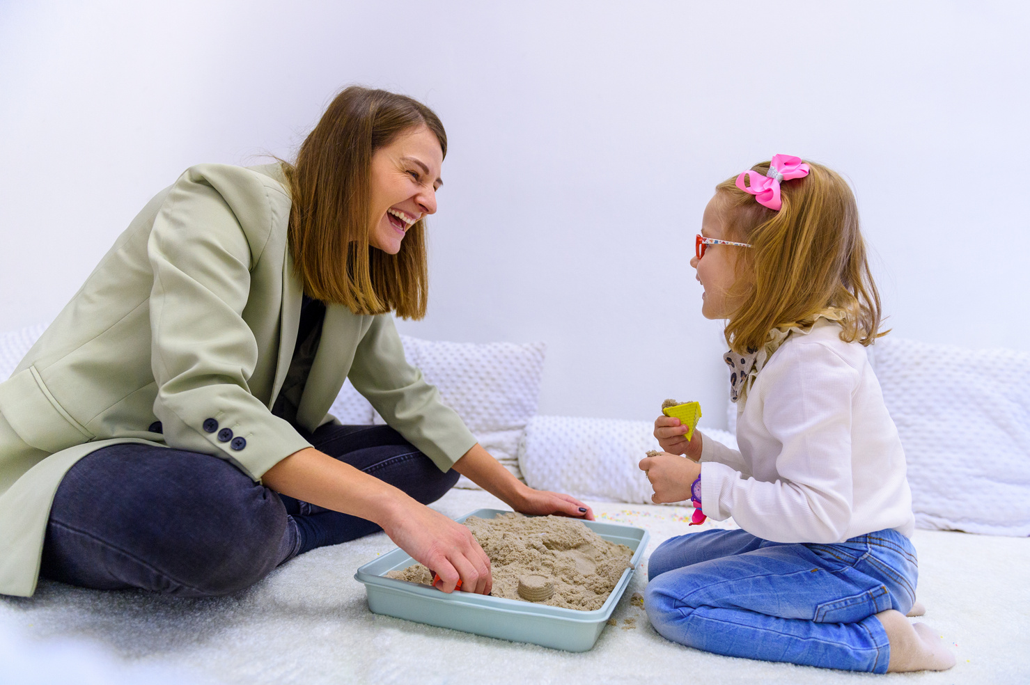 Young girl and her therapist interacting during occupational therapy. Child therapy background.